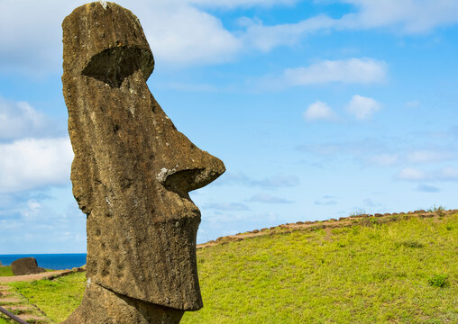 Close-up image showing the head of a standing moai against a blue sky; Easter Island, Chile