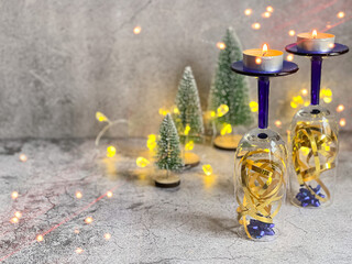 Champagne glasses, decoratively decorated to prepare for the New Year with candles.Postcard with copy space. The use of bokeh