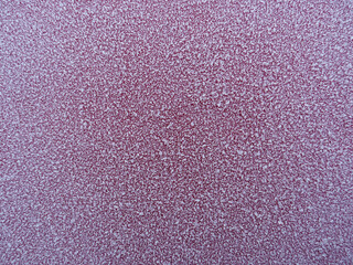 Textured white frost grains on red colour background.