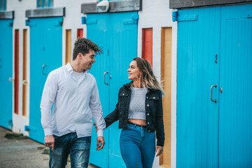 Portrait of a young couple showing affection while they walk together; Wellington, North Island, New Zealand