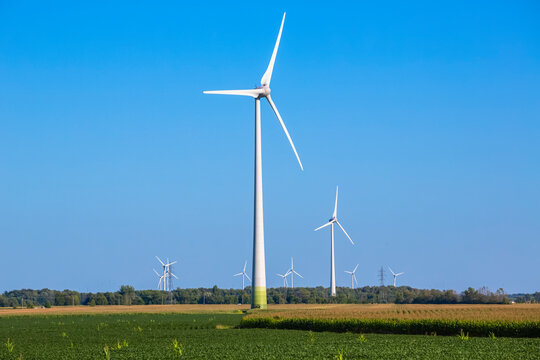 Wind turbines on farmland with a farm field in the foreground; Saint Remi, Quebec, Canada