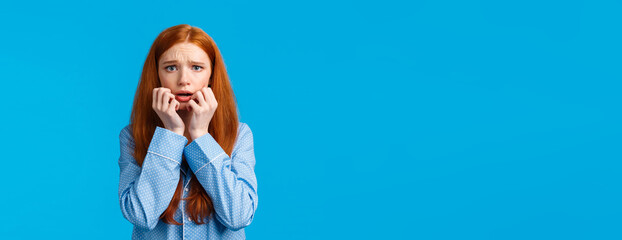 Scared and panicking young worried redhead teenage girl having sleepover with girlfriend, telling...