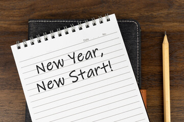 New Year, New start text on note pad with pen