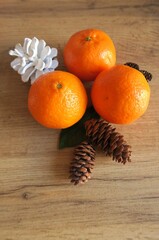 Mandarin slices on a wooden table with Christmas cones