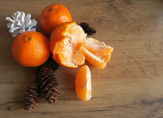 Mandarin slices on a wooden table with Christmas cones