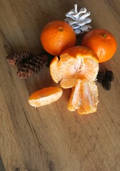 Mandarin slices on a wooden table with Christmas cones