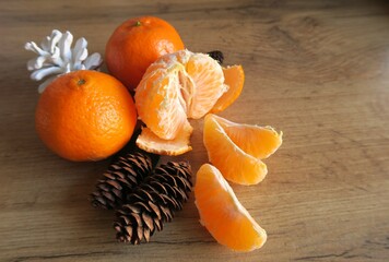 Mandarin slices on a wooden table with Christmas cones