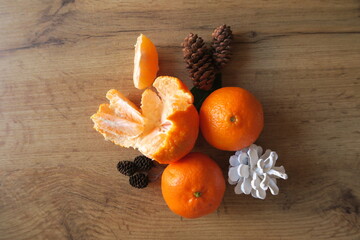Mandarin slices on a wooden table with Christmas cones
