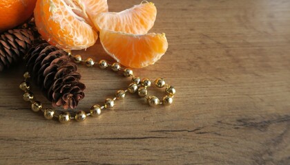 Mandarin slices on a wooden table with golden beads