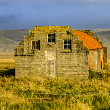 Orange quonset hut on farmland; Myrdalshreppur, Southern Region, Iceland