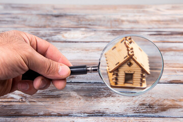 magnifying glass and wooden house model on the table