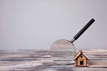 magnifying glass and wooden house model on the table