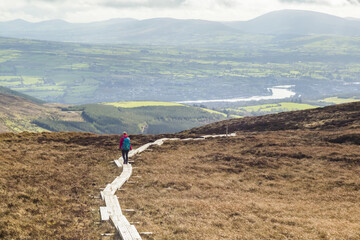 Wooden board walk leading across a moor on aa mountain with a river and fields in the distance; Killaloe, Clounty Clare, Ireland