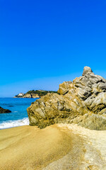 Big surfer waves and rocks at beach Puerto Escondido Mexico.