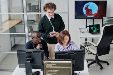 Group of developers working in team in modern office, they writing codes on computer