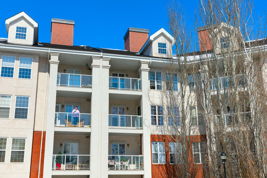 A woman stands on her balcony getting fresh air during isolation, Covid-19 world pandemic; St. Albert, Alberta, Canada