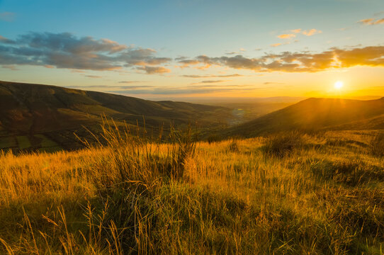 Sunset in summer over the Silvermine Mountains with tall grass in the foreground overlooking a valley; County Tipperary, Ireland