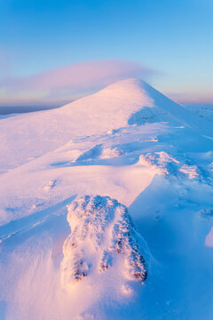 Snow drifts forming on the rocks along the peak of the Galty mountains at sunrise; County Tipperary, Ireland