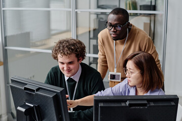 Group of young IT programmers working with codes on computers in team