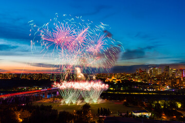 Fireworks in a city at dusk; Alberta, Canada