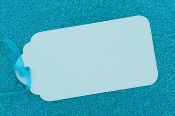 Blank teal gift tag on glitter paper