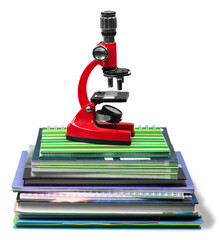 Microscope on pile of books and notebooks isolated on white