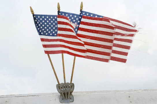 Three American flags blowing in the wind