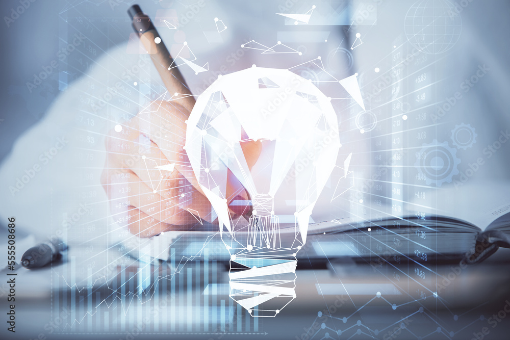 Poster bulb hologram over hands taking notes background. concept of idea. double exposure