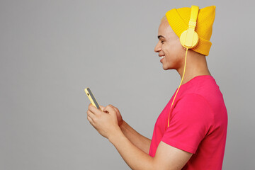 Side profile view young man of African American ethnicity 20s he wear pink t-shirt yellow hat...