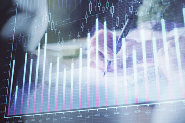 Financial forex graph displayed on hands taking notes background. Concept of research. Multi exposure