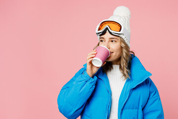 Snowboarder woman in blue suit goggles mask hat ski padded jacket hold cup coffee to go look aside...