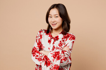 Young fun smiling woman of Asian ethnicity wear red shirt look camera hold hands crossed folded...