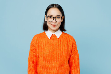 Young satisfied smiling happy fun cheerful smart woman of Asian ethnicity wear orange sweater...