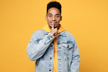 Young fun man of African American ethnicity wear denim jacket hoody look camera say hush be quiet...