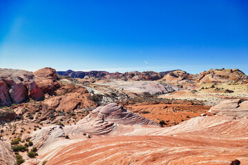 Arid landscape with striated red and white rocks along the White Domes Trail, Valley of Fire State Park, Nevada, USA.
