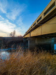 Metal Bridge crossing over small river creek in winter/fall during sunset vertical