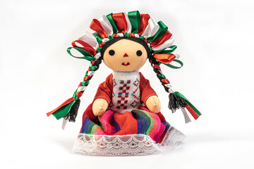 Colorful traditional Mexican rag handmade doll isolated in white.
Doll with long braids and ribbons using the colors of the Mexican flag.
