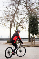 Fototapeta na wymiar older man riding a mountain bike, equipped and healthy