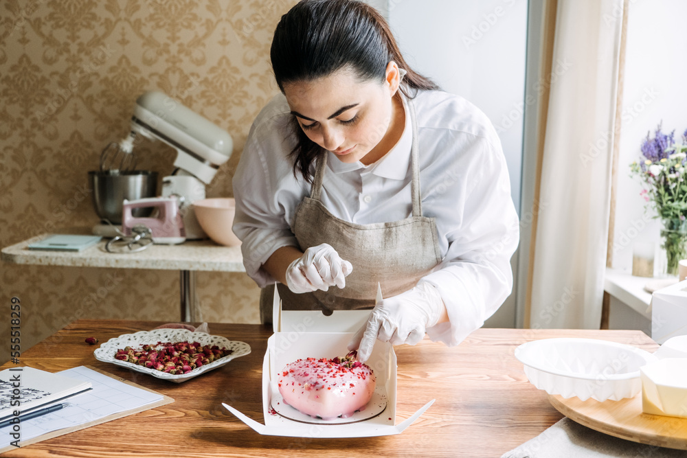 Wall mural Valentines Day Marketing Ideas for Small Businesses. Confectioner chef make heart shape pink Mirror Glaze mousse cake