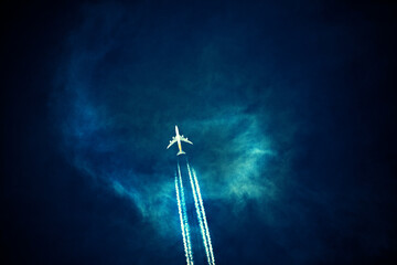 Commercial Airplane with Contrails in Dark Sky