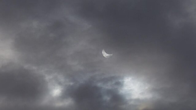 A solar eclipse in cloudy weather through a cloud. partial solar eclipse.