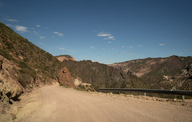 Travel. View of the dirt road across the arid desert and mountains.