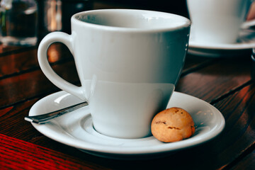  a cup of espresso  coffee served with a cookie on wooden table. Vintage, romantic coffee concept