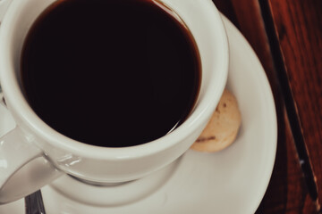 Top view of a cup of espresso served with cookie. Vintage, romantic coffee concept