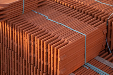 Obraz na płótnie Canvas Stack of new ceramic roof tiles on construction site.