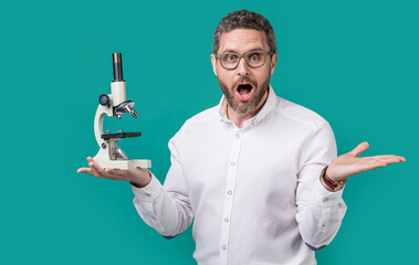 amazed man holding invention microscope in studio. man microscope for invention.