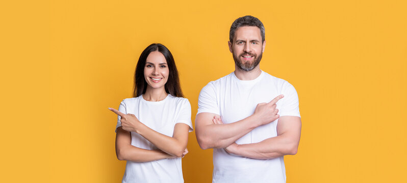 Happy couple pointing fingers. Couple presenting product for advertisement banner