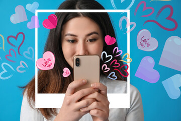 Beautiful young Asian blogger with mobile phone on blue background. Valentine's Day celebration