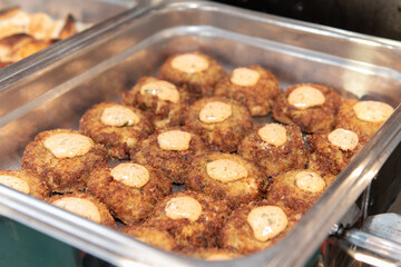Buffet table with a chaffing dish full of crispy crabcakes for the party guests to eat