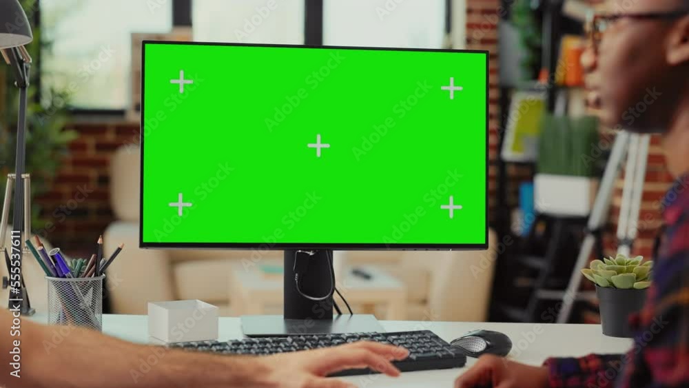 Poster multiethnic team working on computer with greenscreen at home, using monitor to examine isolated dis
